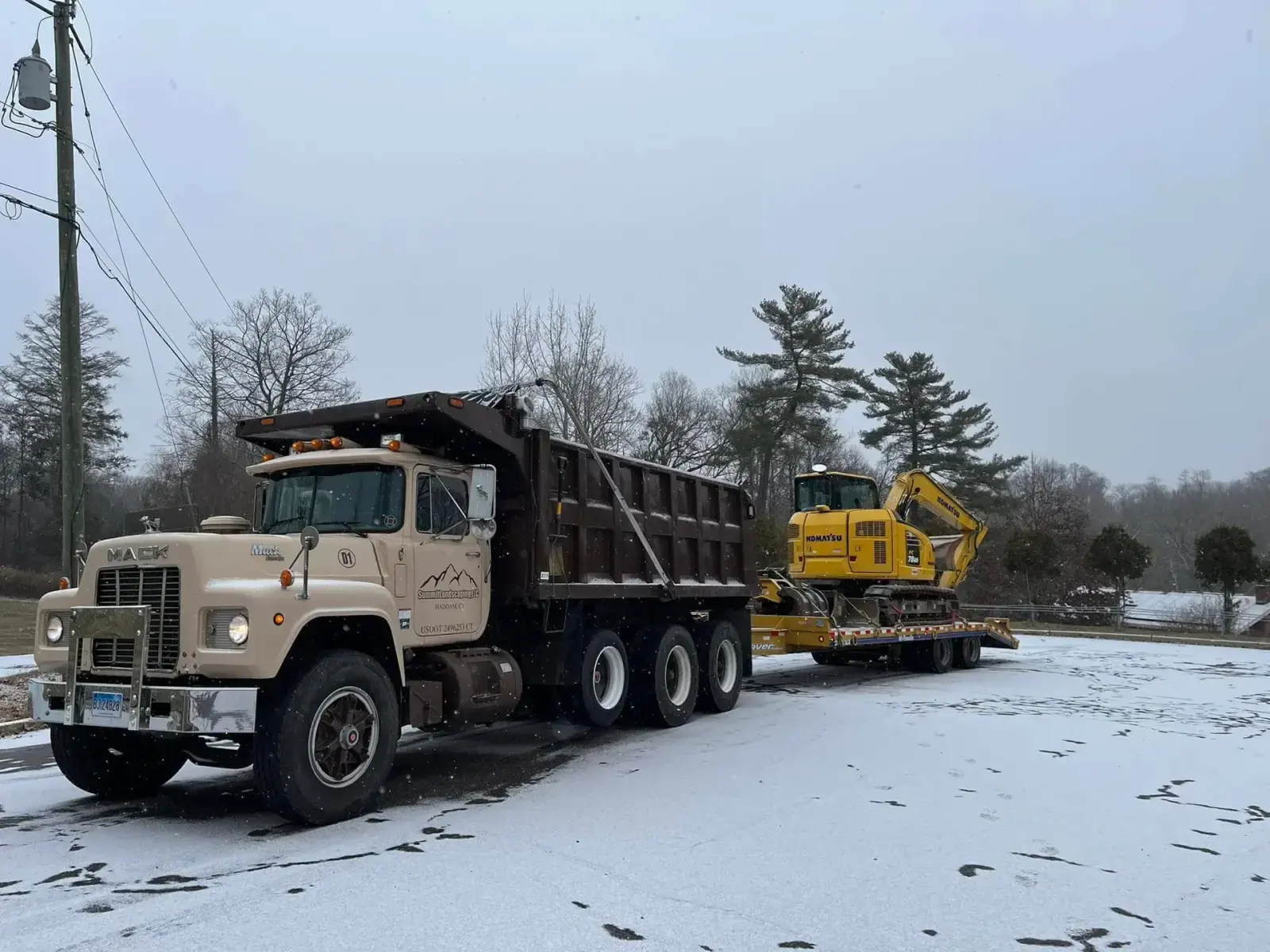Summit's Mack dump truck and Komatsu excavator loaded for a Connecticut site-work job